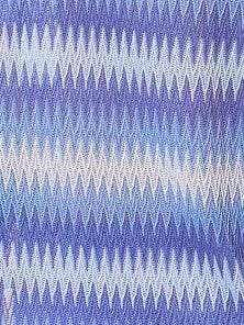 Mialur Boutique - A close-up of a woven fabric with a repeating chevron or zigzag pattern in shades of blue, lavender, and white.
