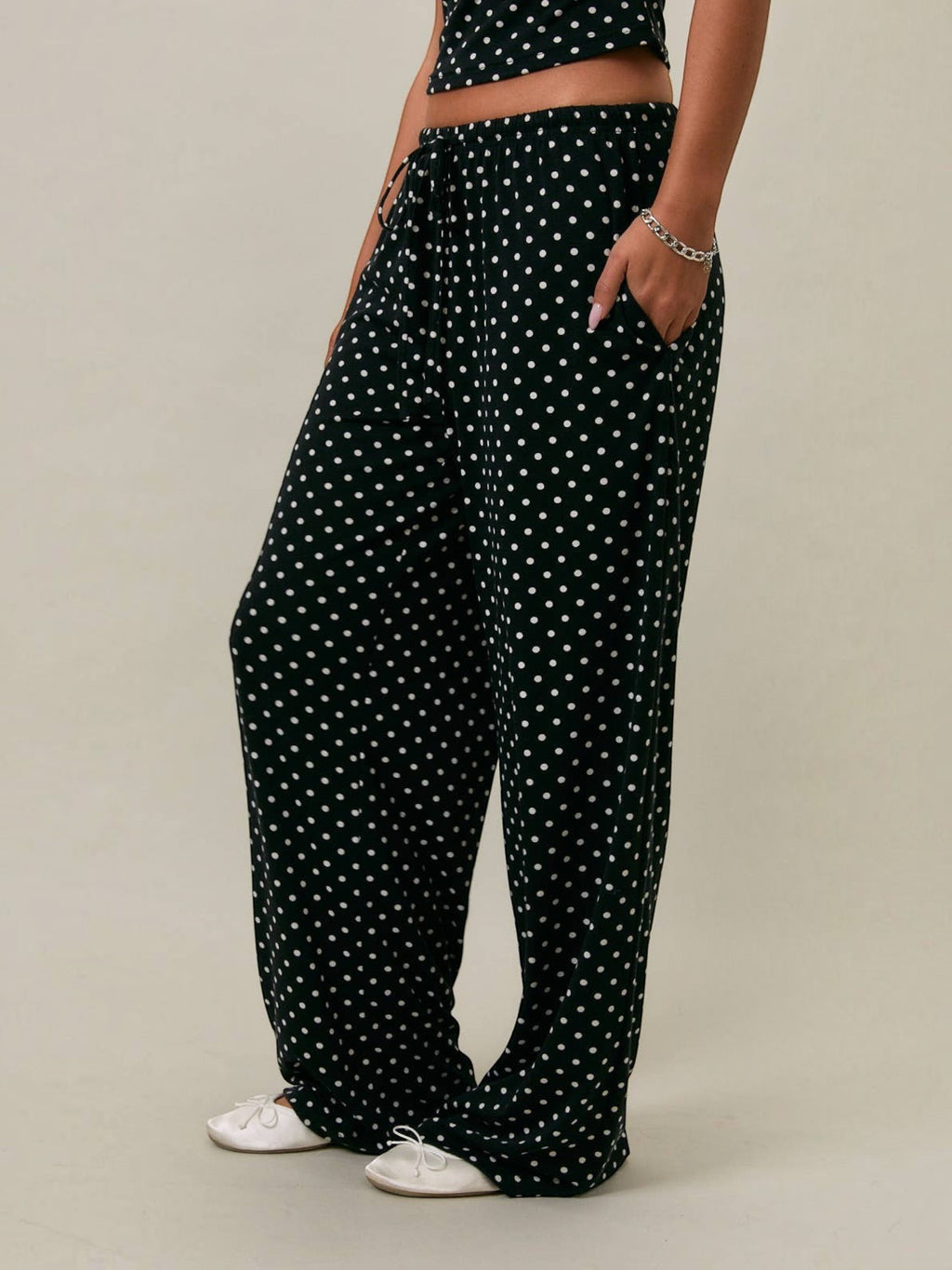 Mialur Boutique Luna Polka Dot Pants shown from the side, featuring black and white all-over polka dot print, wide-leg silhouette, side pockets, and elastic drawstring waistband