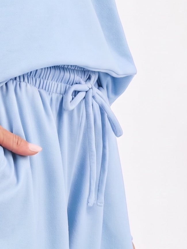 Mialur Boutique - Close-up of a light blue lounge set featuring a drawstring waist and side pockets, with a hand reaching into one of the pockets.