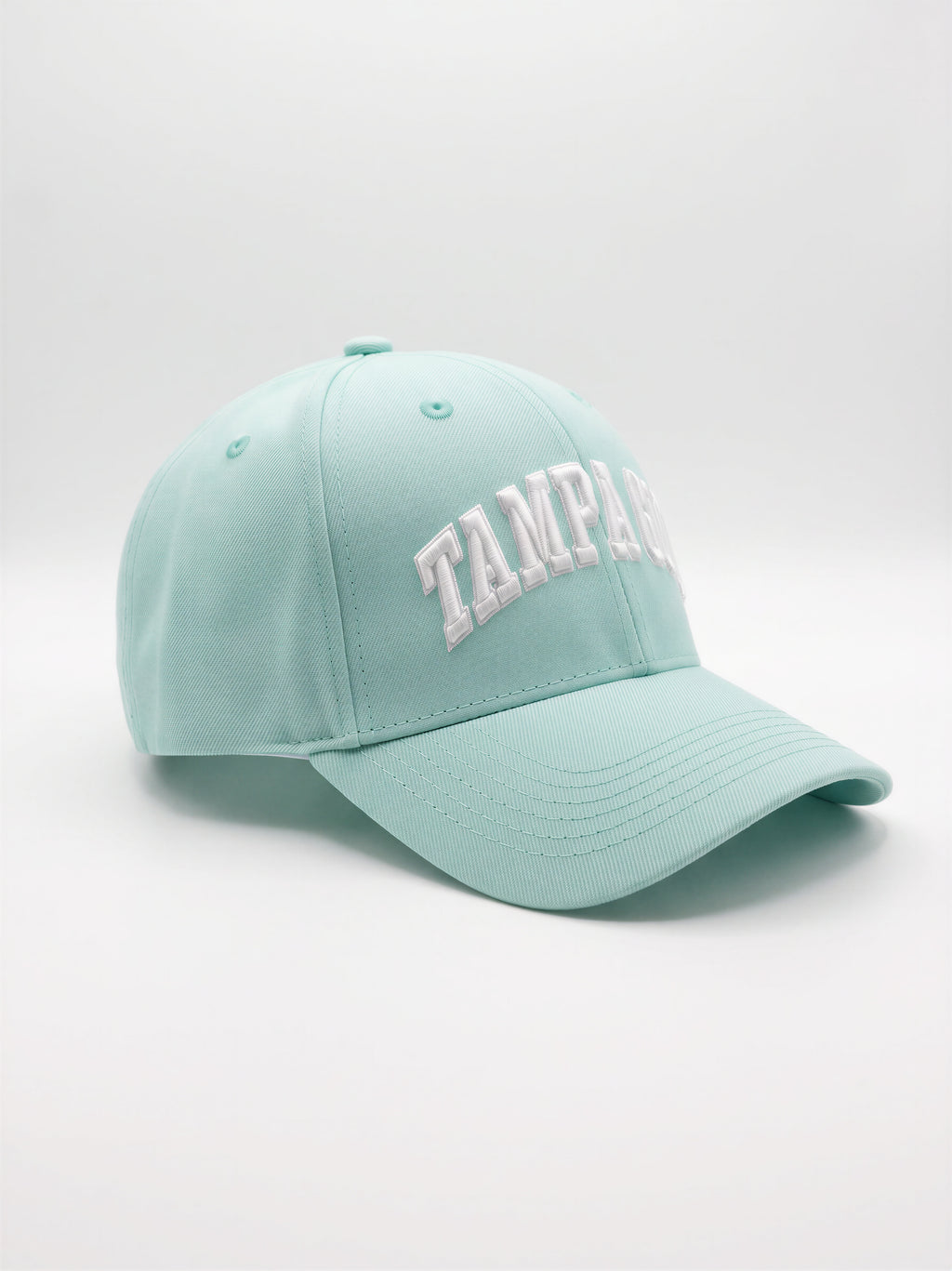 Mialur Boutique - A light mint green baseball cap with 'TAMPA' embroidered in white arched letters on the front, set against a neutral light gray background.