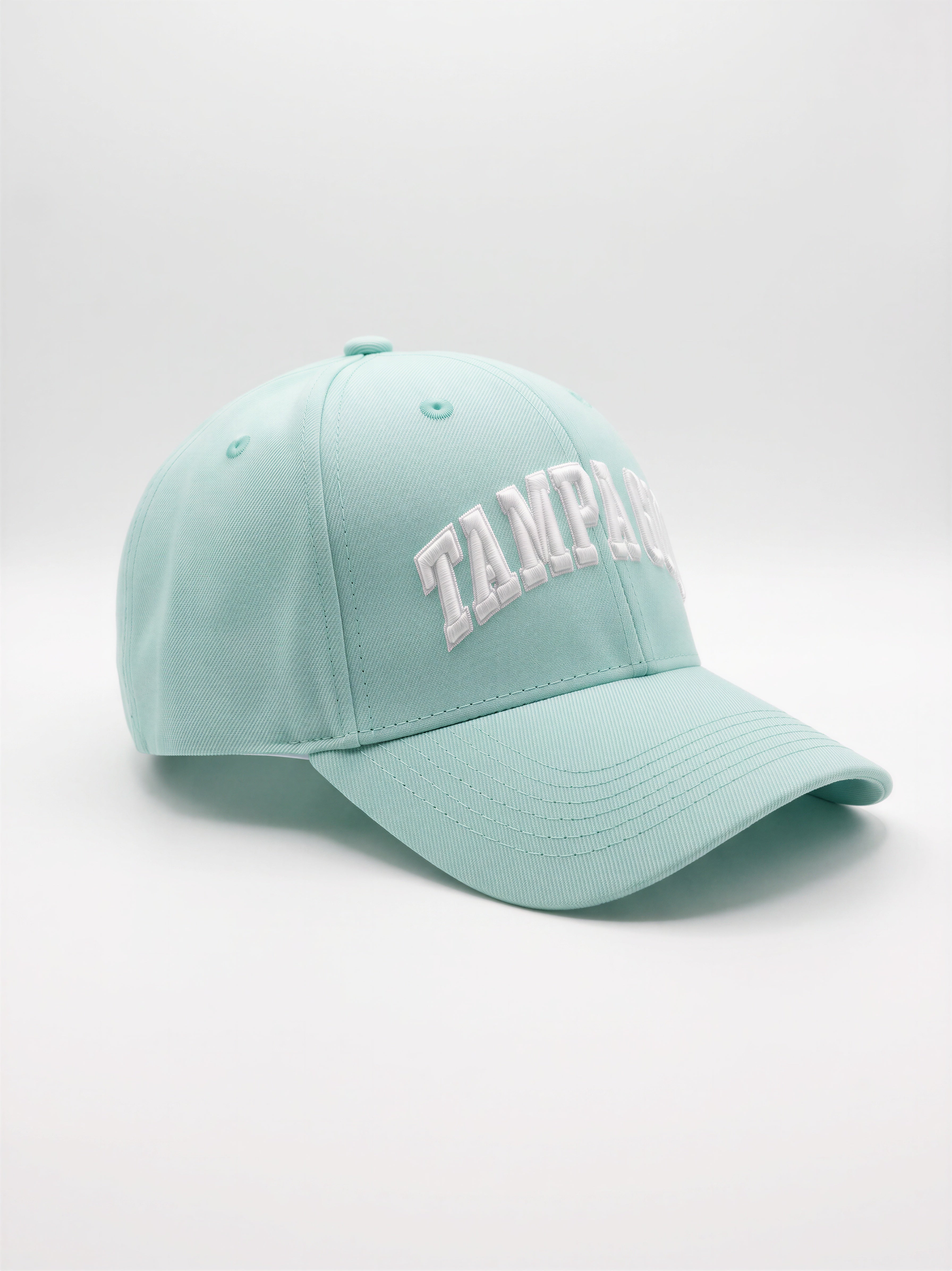 Mialur Boutique - A light mint green baseball cap with 'TAMPA' embroidered in white arched letters on the front, set against a neutral light gray background.
