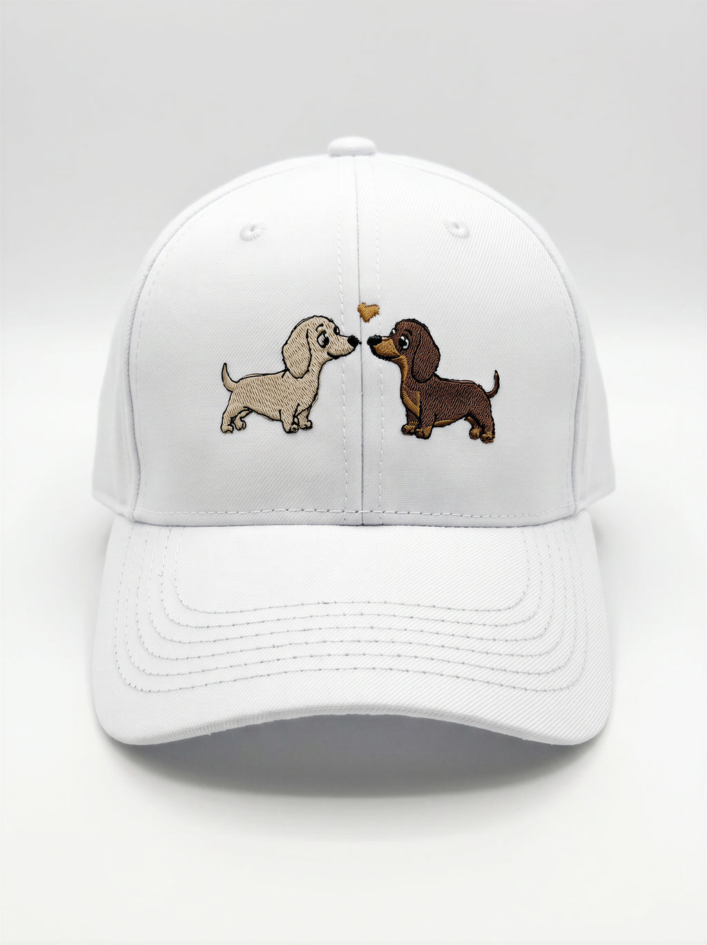 Mialur Boutique - A white baseball cap featuring an embroidered design of two dachshund dogs facing each other with a small heart between them, set against a clean white background.