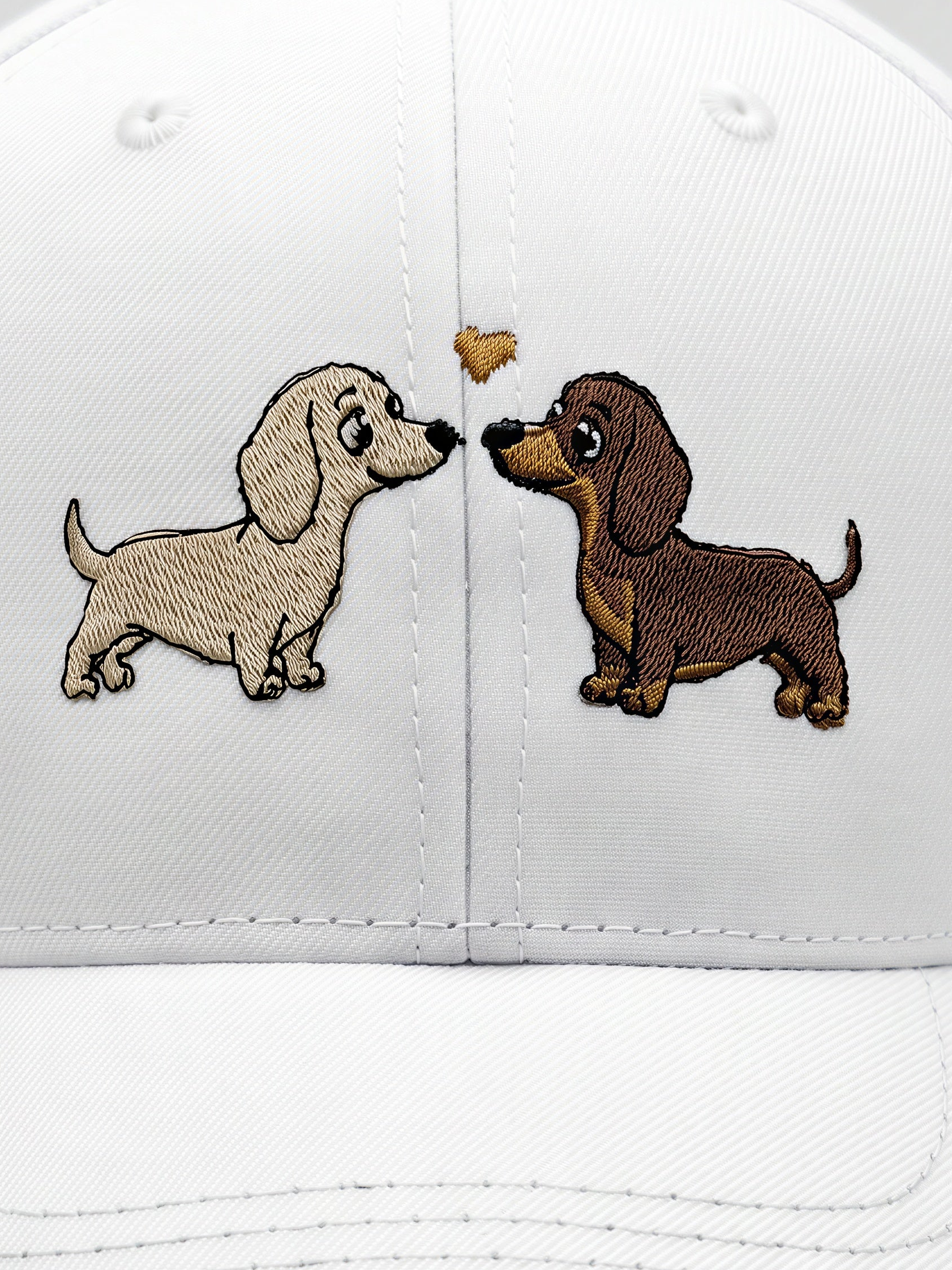 Mialur Boutique - White baseball cap featuring embroidered cartoon dachshunds facing each other with a small gold heart between them.