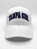Mialur Boutique - A white baseball cap featuring the words 'TAMPA GIRL' embroidered in navy blue arched block letters across the front, set against a neutral light gray background.