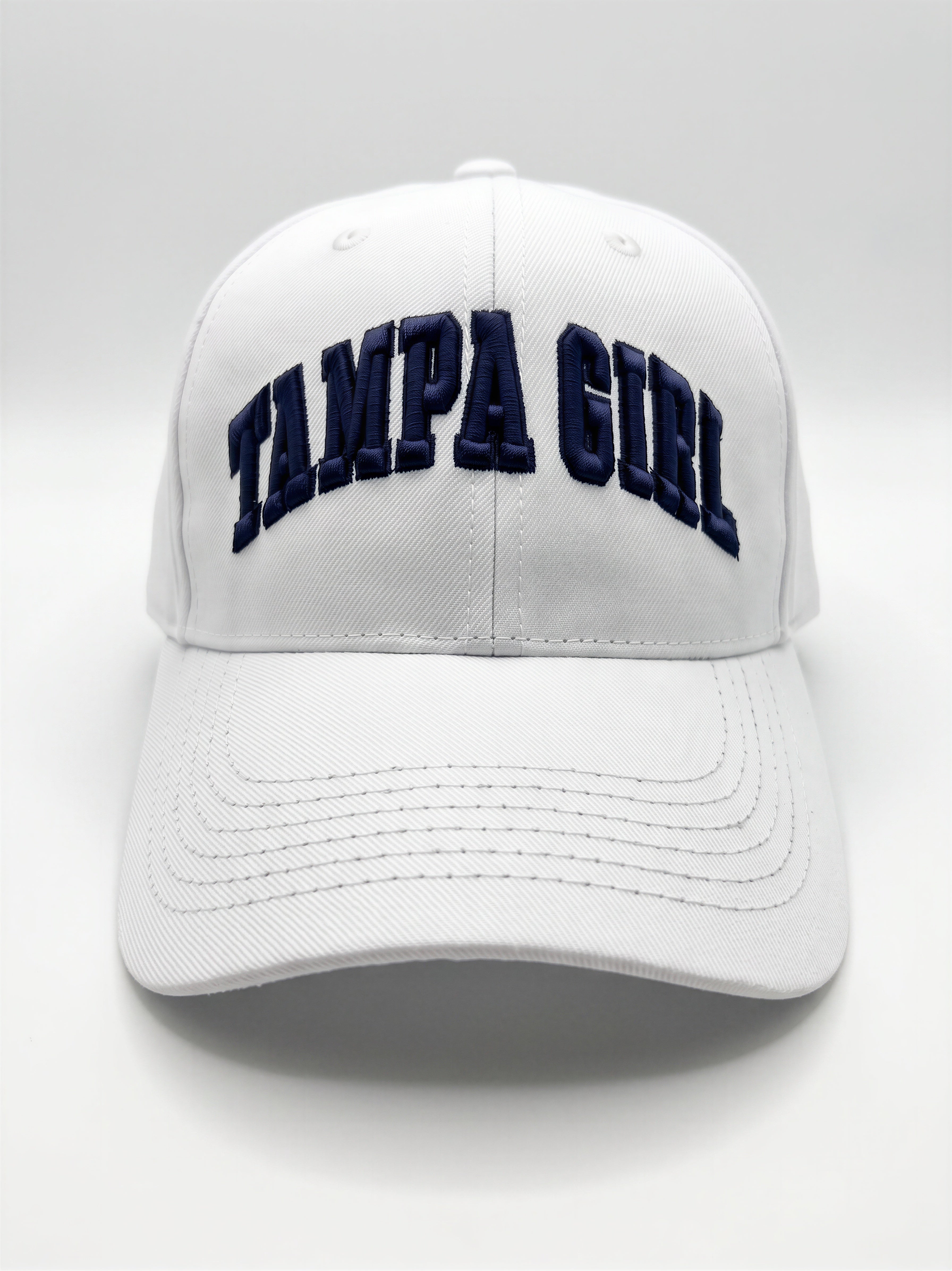 Mialur Boutique - A white baseball cap featuring the words 'TAMPA GIRL' embroidered in navy blue arched block letters across the front, set against a neutral light gray background.