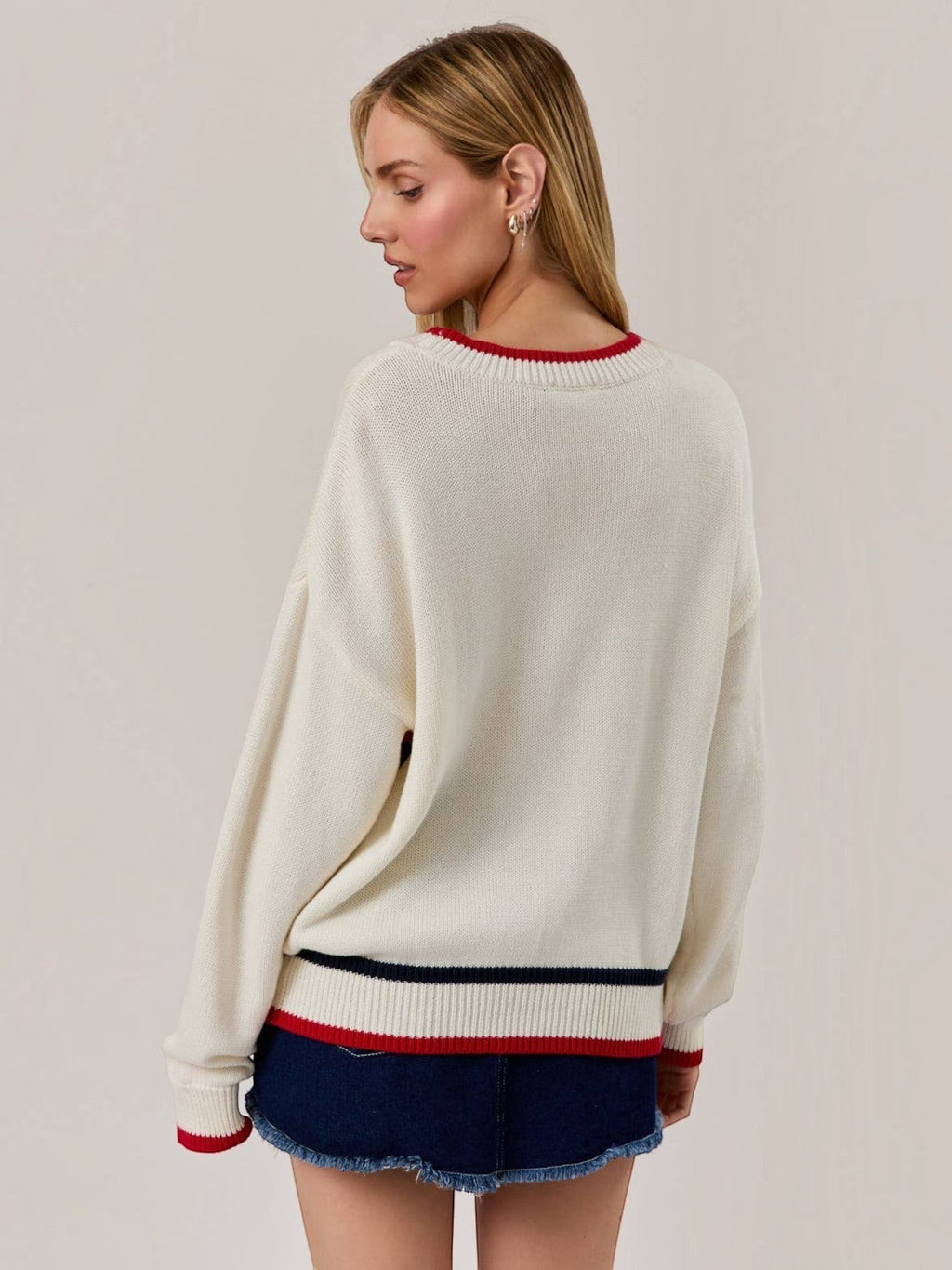 Mialur America knit sweater in white with red and navy striped cuffs and hem, shown from the back on a model.