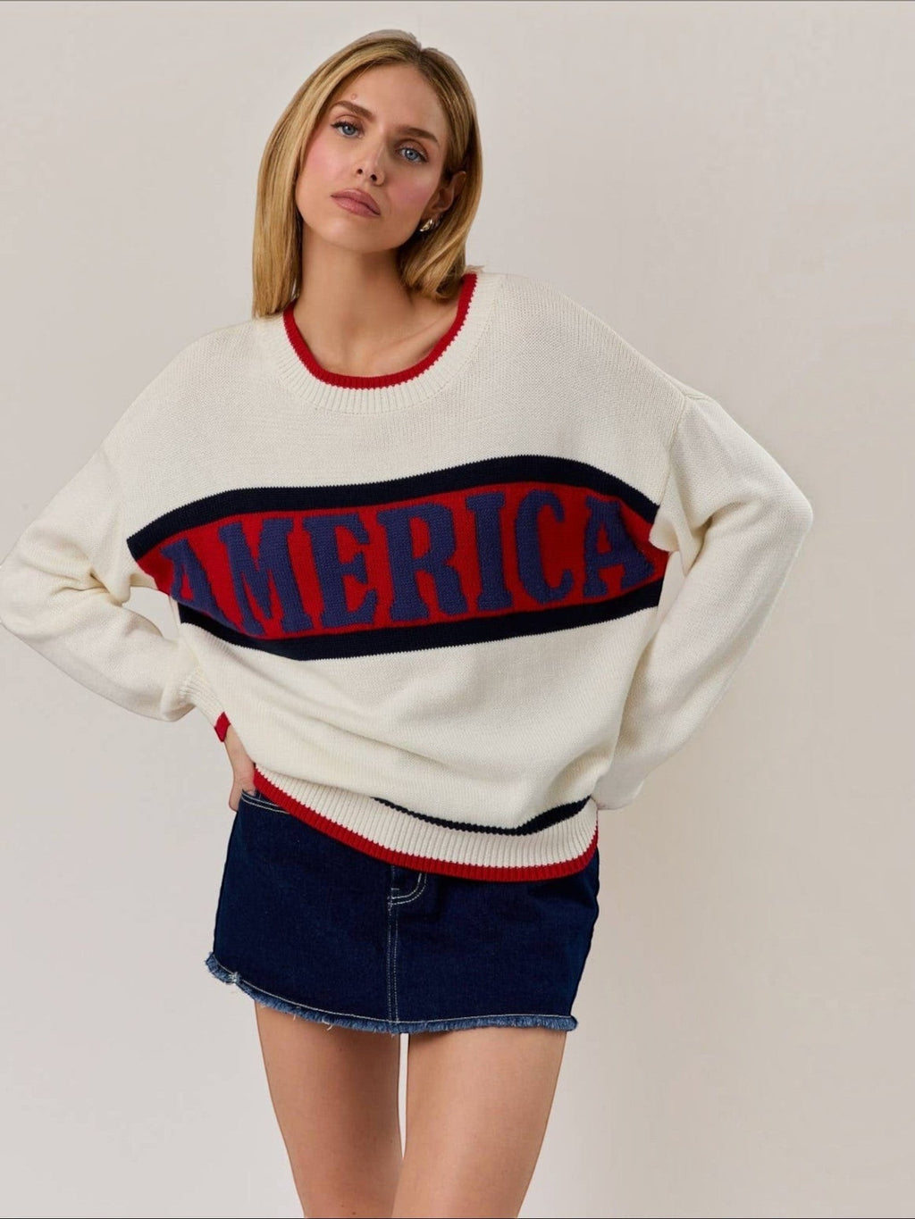 Mialur America knit sweater in white with red and navy stripes and collegiate lettering worn by a blonde model