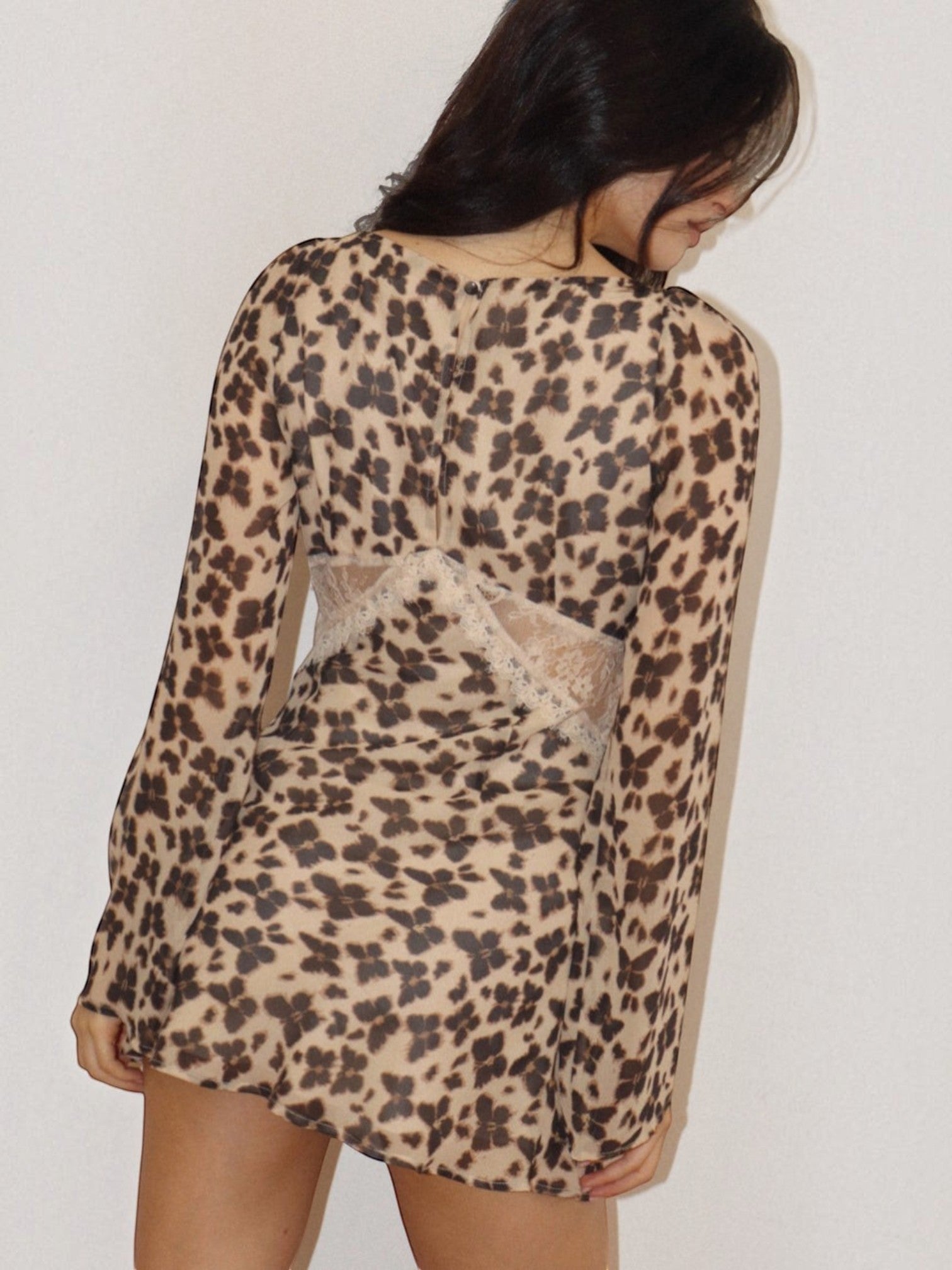 Back view of a Mialur brown and beige animal print mini dress with sheer lace waist detailing and long sleeves.