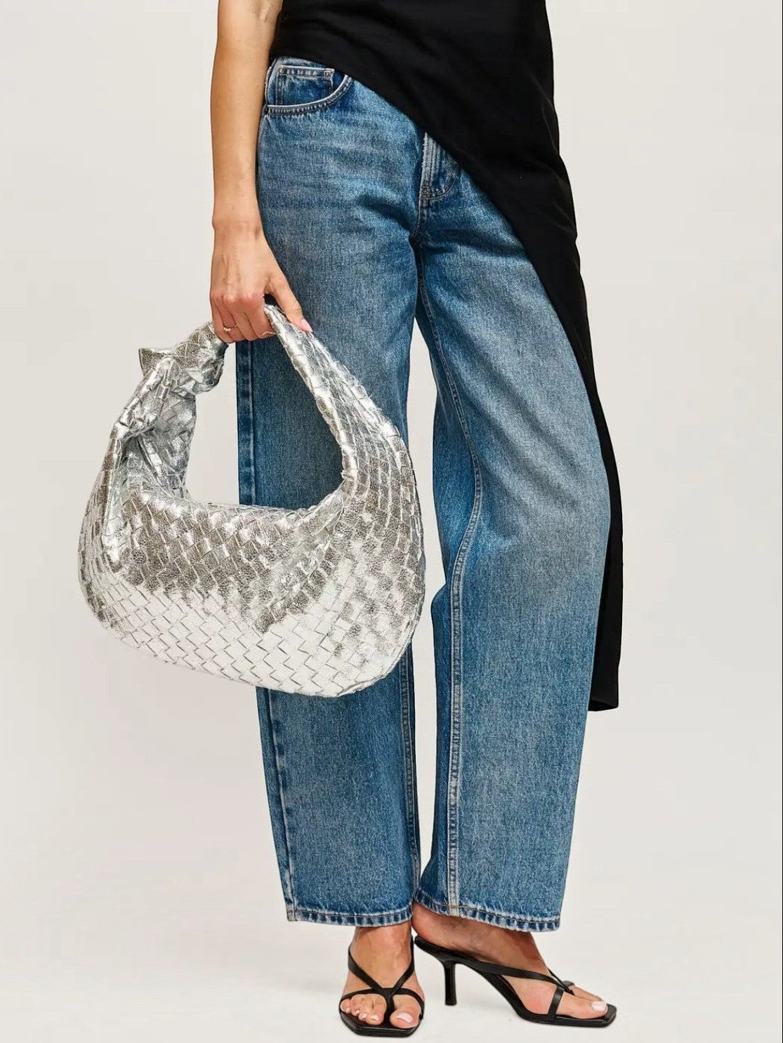 Mialur Aspen Bag in metallic silver with a woven texture, styled as a slouchy hobo bag with blue jeans and heels.