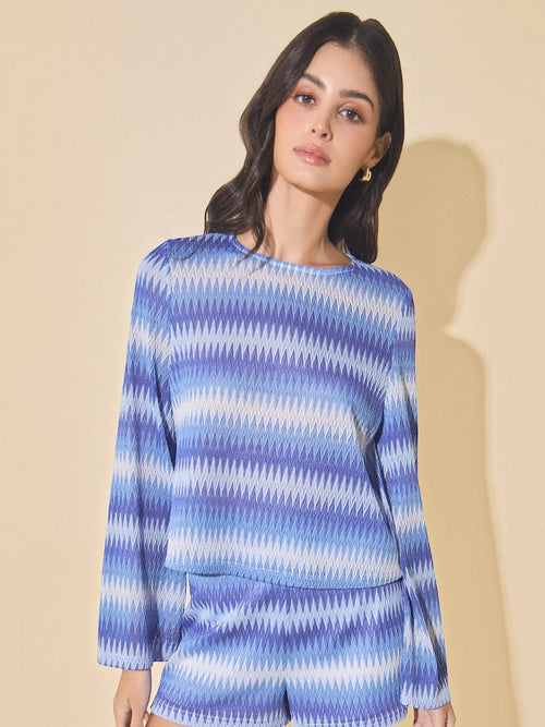 Model wearing Mialur Azure Waves bell sleeve sweater in blue and white wave-patterned lightweight knit fabric.
