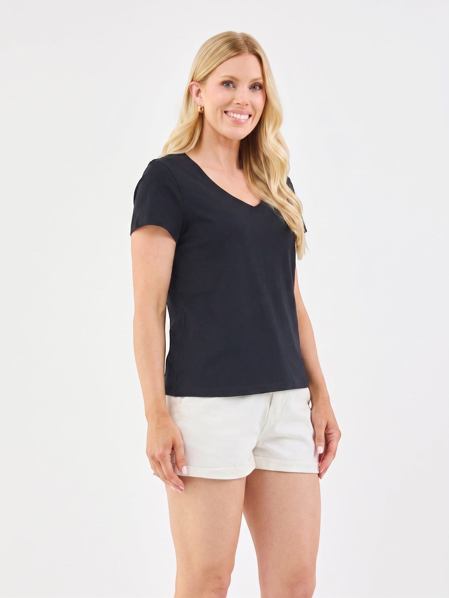 A blonde woman wearing a Mialur black 100% cotton V-neck short-sleeve tee with white shorts against a white background.
