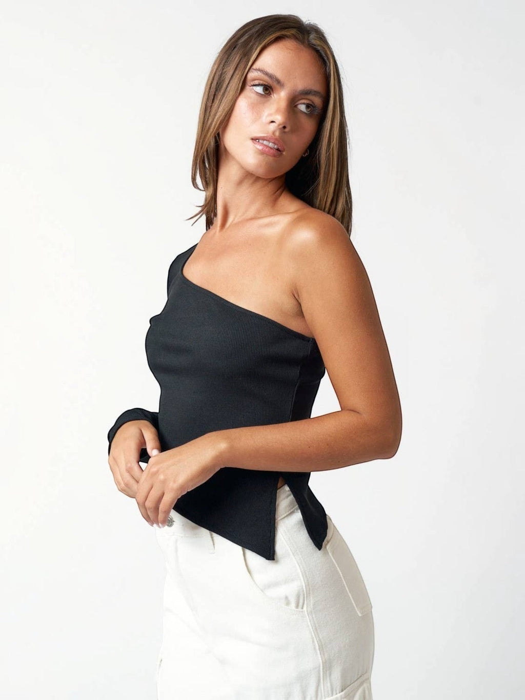 Model wearing a Mialur black one-shoulder long sleeve top with a ribbed texture and side slit detail