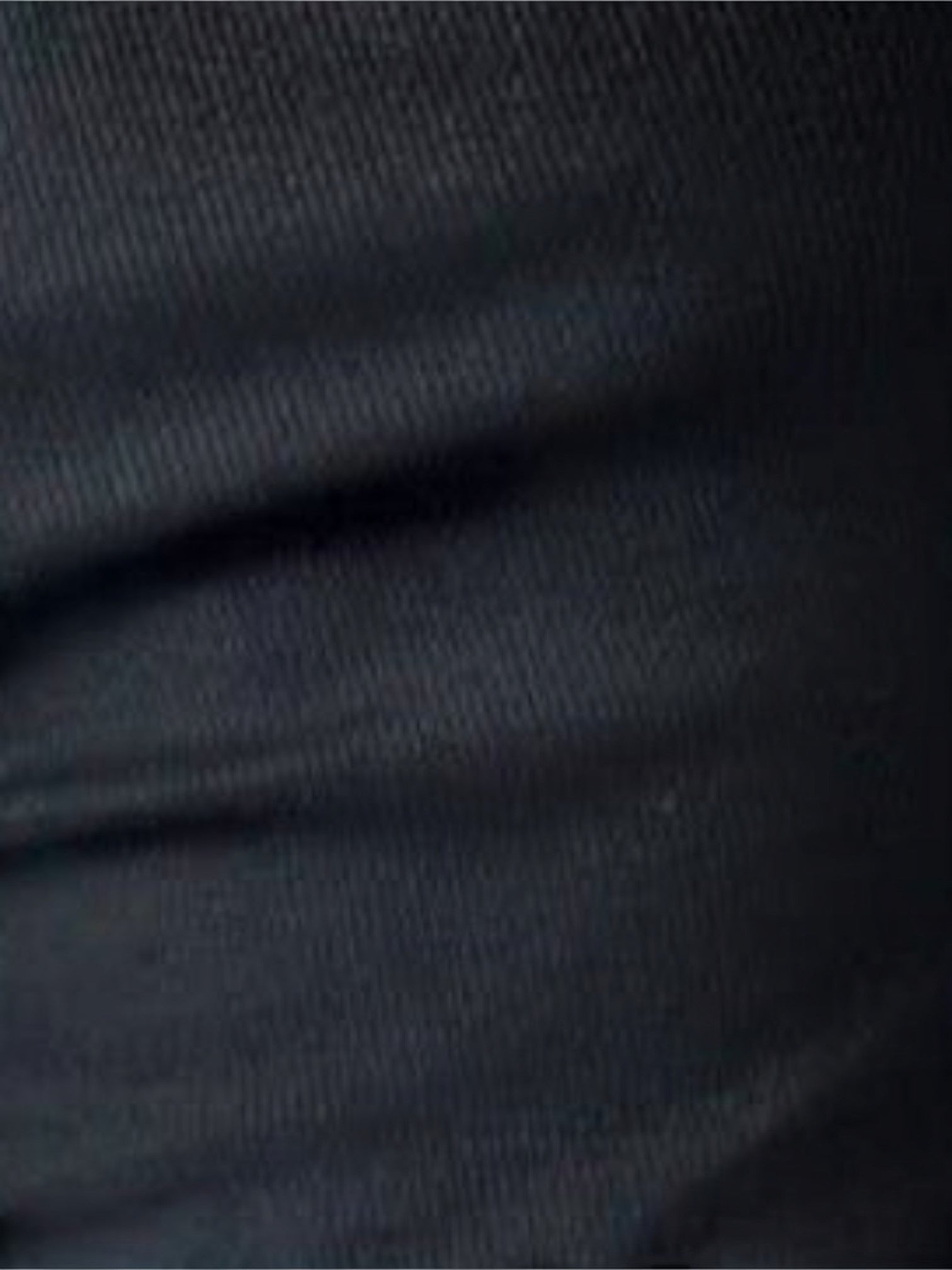 Close-up of the soft black ribbed fabric of a Mialur one-shoulder long sleeve top.