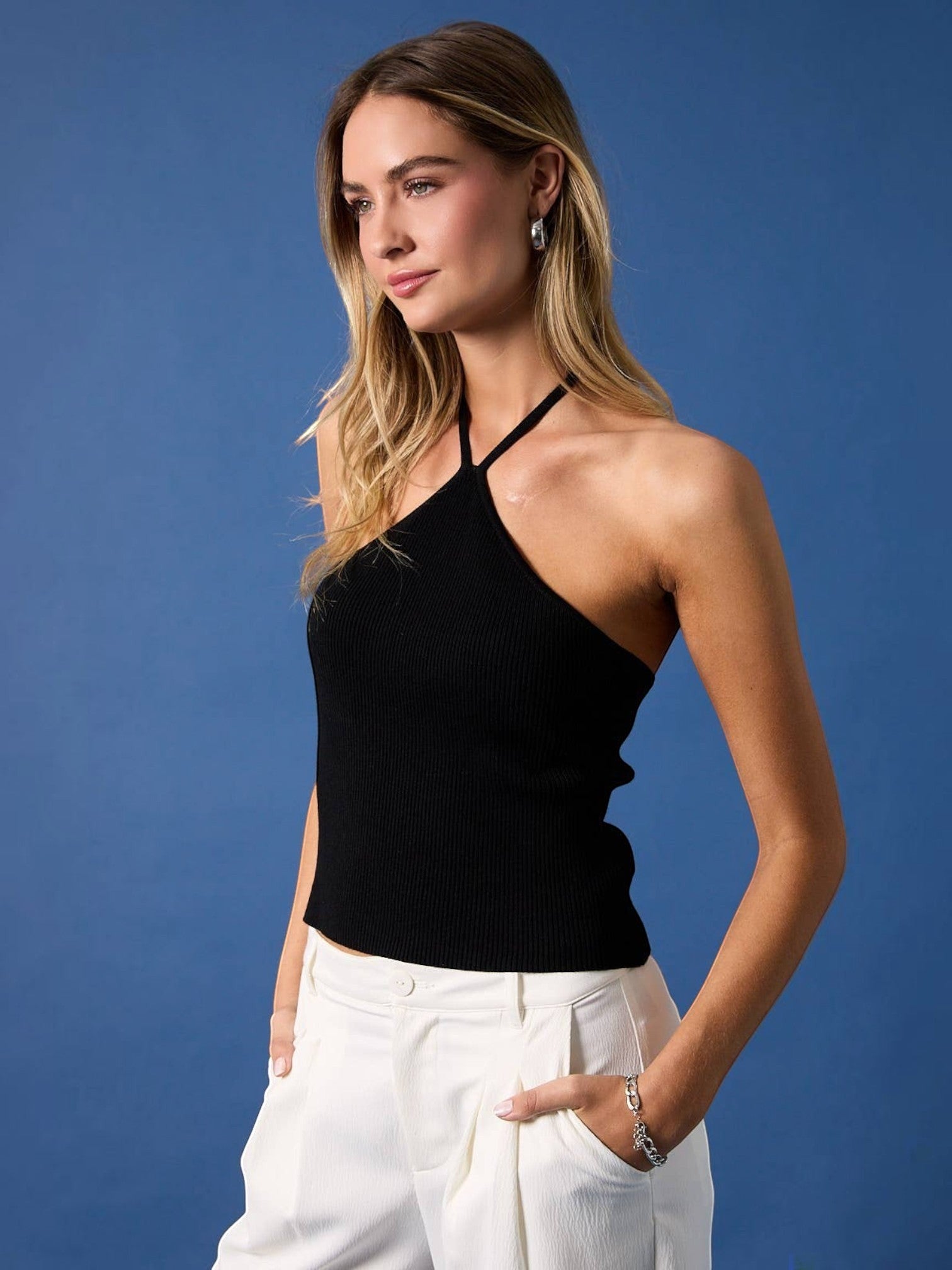 Model wearing a Mialur black ribbed halter top with a fitted silhouette against a blue background
