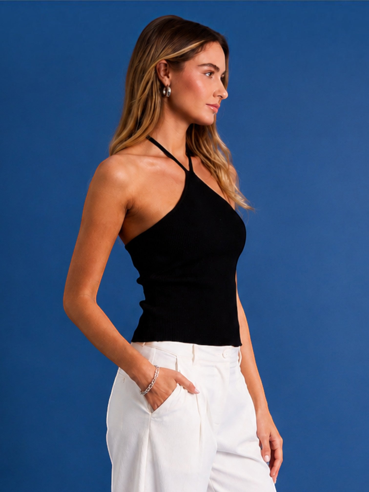 Mialur black ribbed halter top with a fitted silhouette worn by a model against a blue background