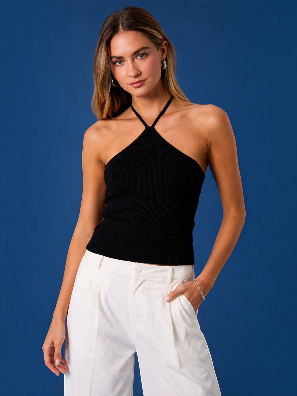Model wearing a Mialur black ribbed halter top with a fitted silhouette against a blue background