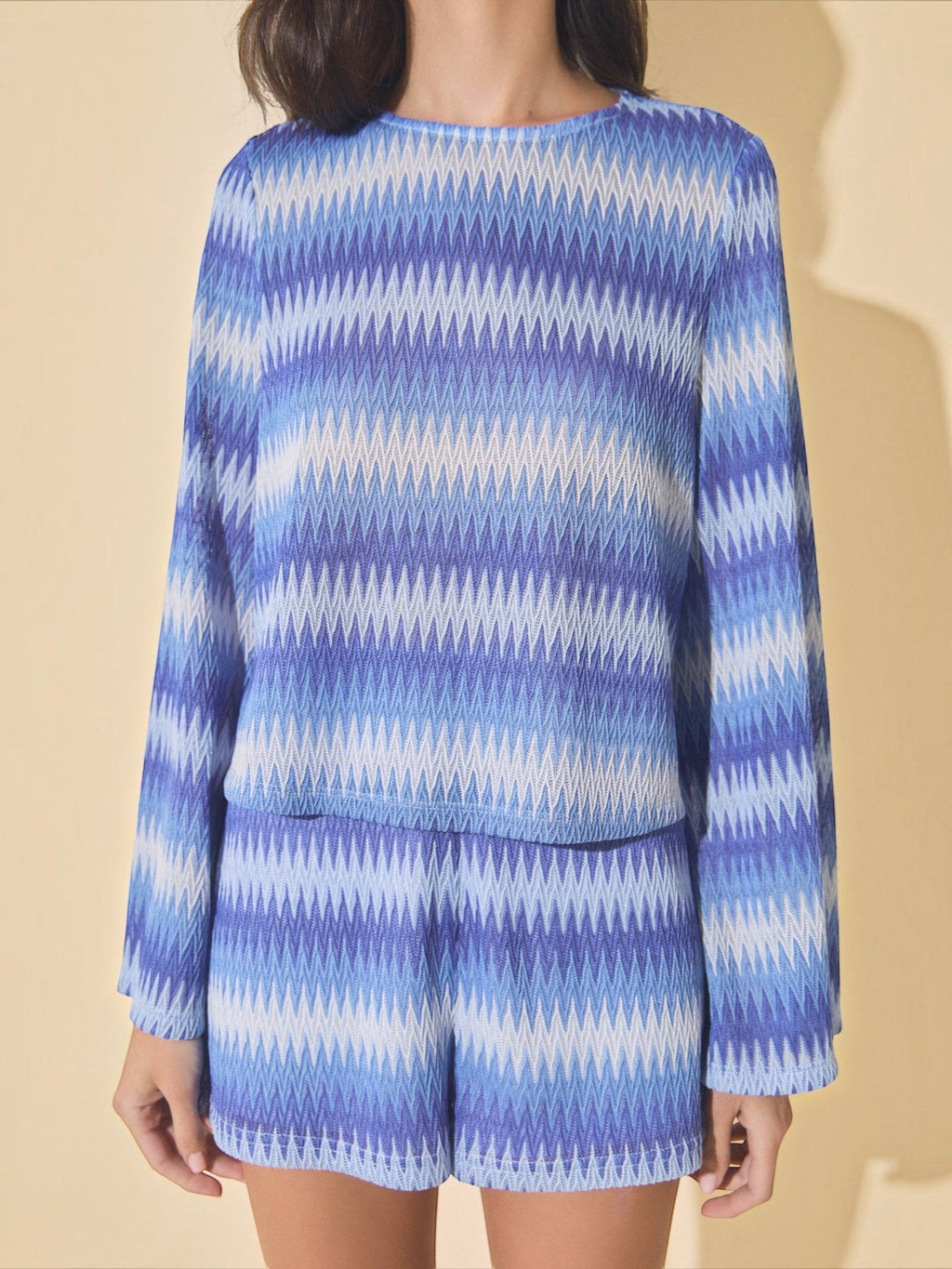 Mialur blue and white wave-patterned knit sweater with bell sleeves worn by a model against a neutral background.