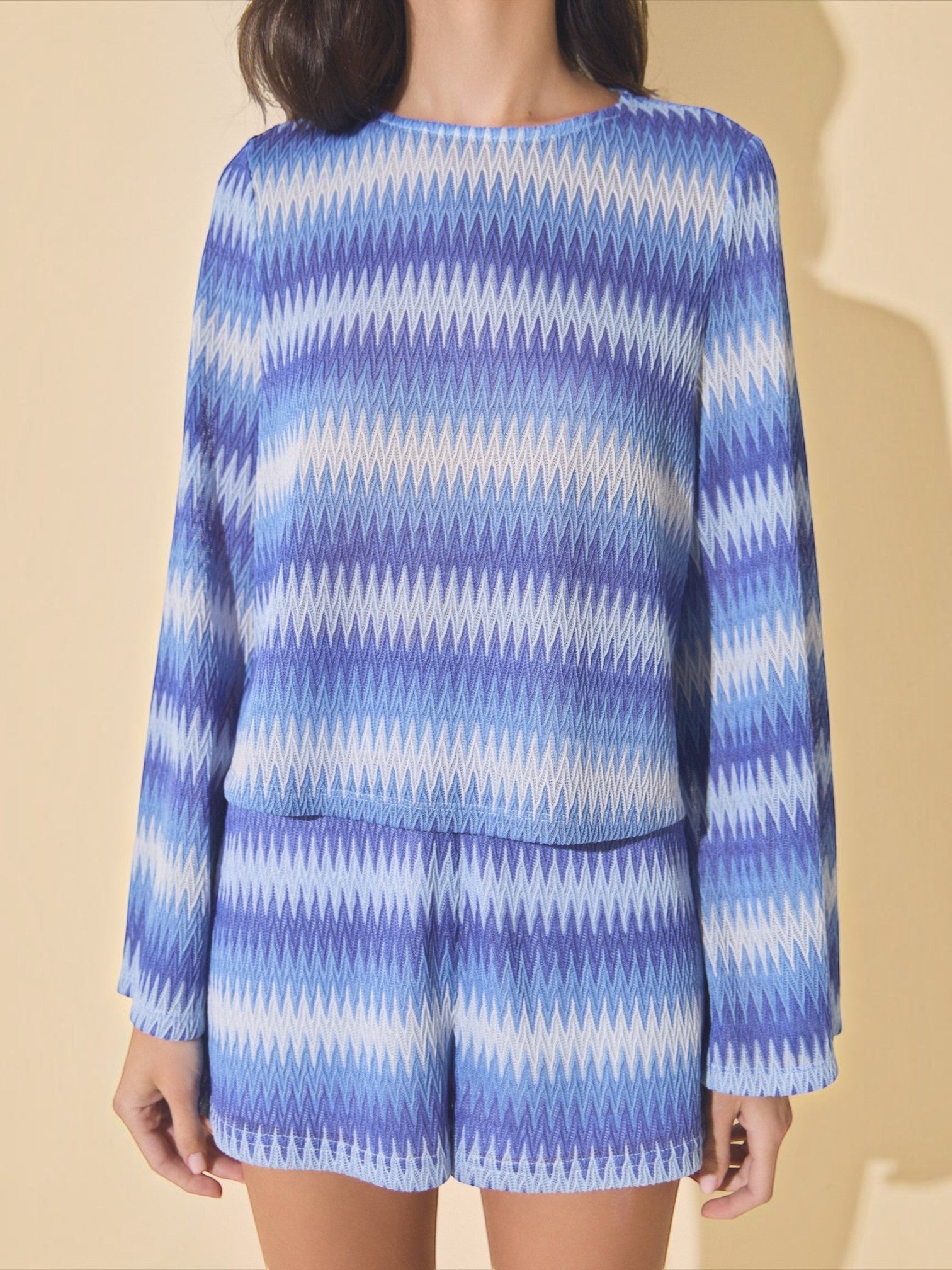 Mialur blue and white wave-patterned knit sweater with bell sleeves worn by a model against a neutral background.