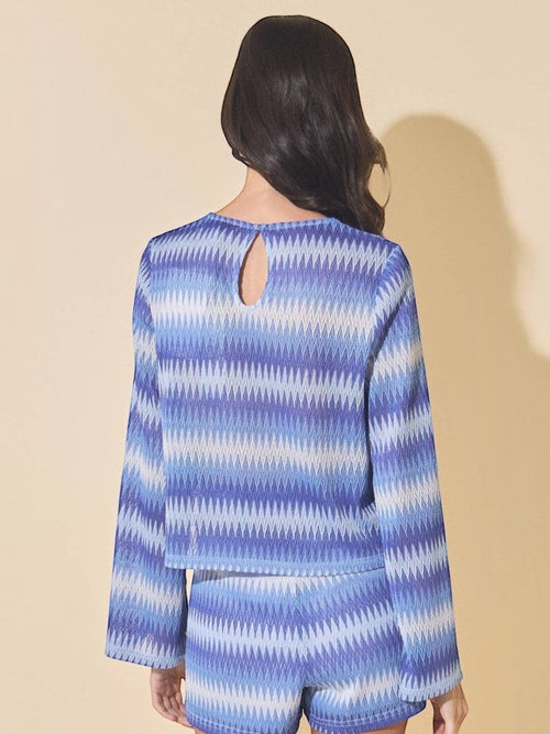 Back view of Mialur blue and white wave-patterned knit sweater with bell sleeves and a keyhole back detail.