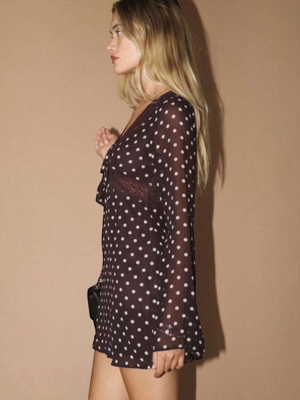 Mialur brown polka dot mini dress with sheer long sleeves and lace trim worn by a blonde model in profile view.