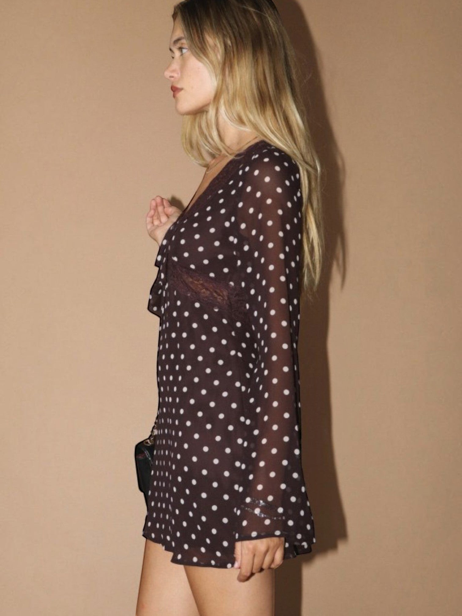 Mialur brown polka dot mini dress with sheer long sleeves and lace trim worn by a blonde model in profile view.