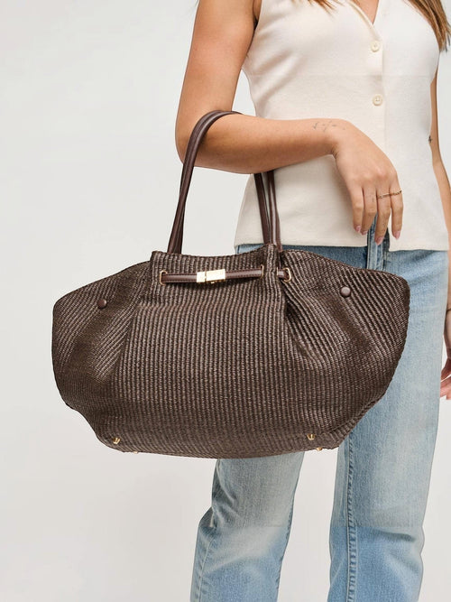 Mialur chocolate brown woven tote bag with gold-tone hardware and shoulder straps, held by a woman in casual attire.