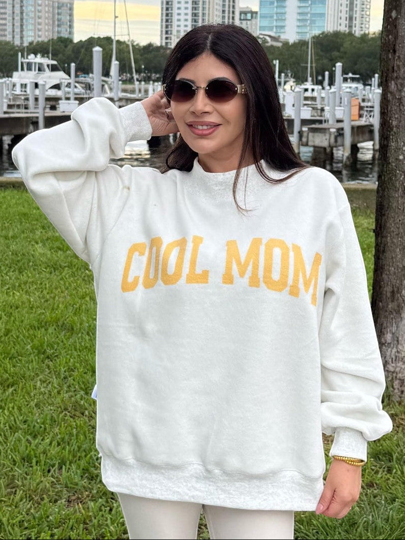Mialur Cool Mom reversible mock neck sweatshirt in white with yellow lettering worn by a woman outdoors