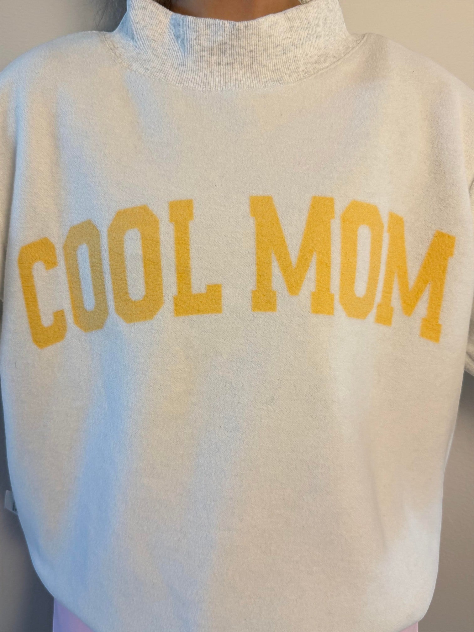 Mialur reversible mock neck top in cream with yellow Cool Mom text printed on the front