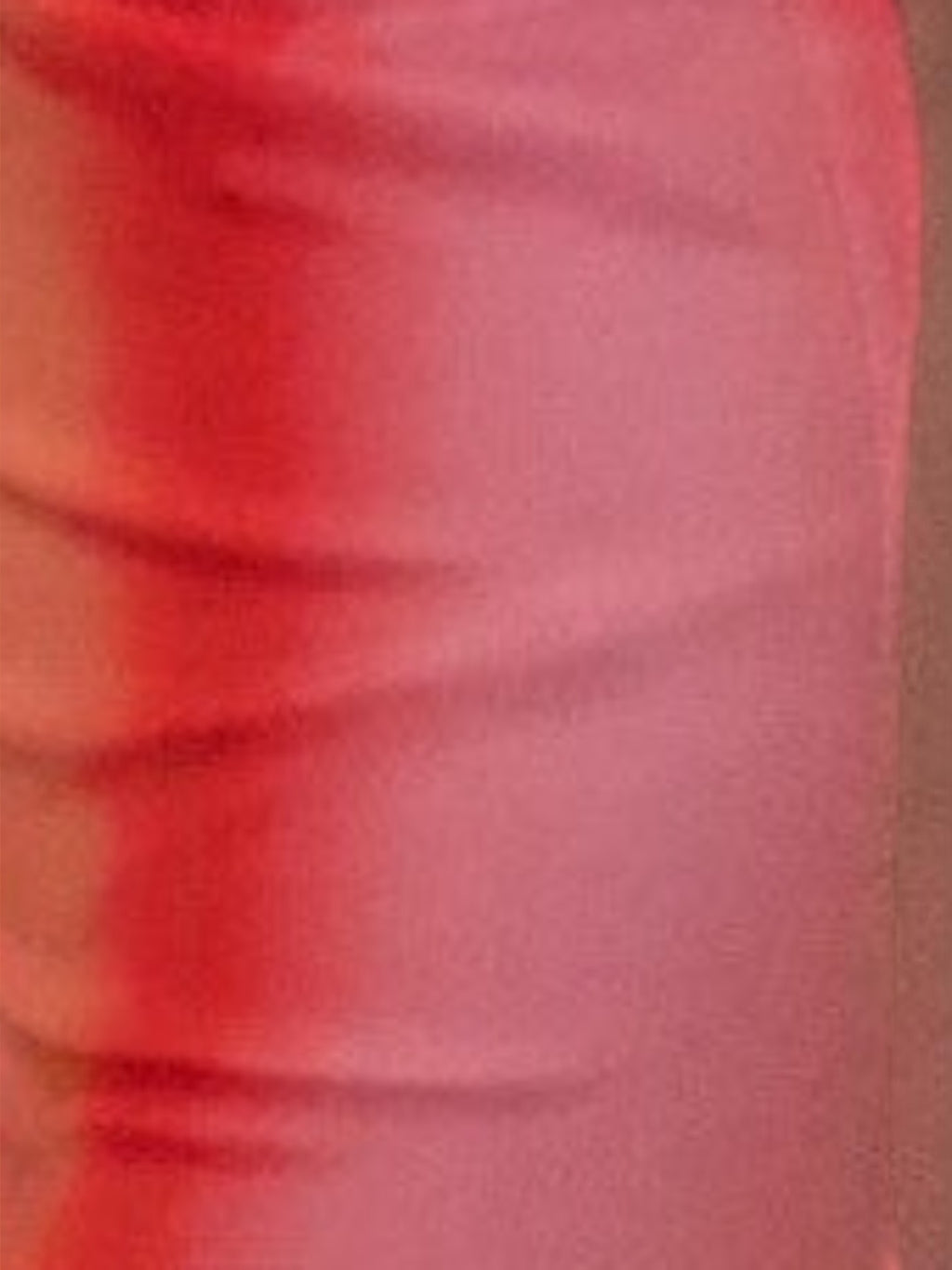 Close-up of the vibrant coral pink fabric of the Mialur Sunset Escape Maxi Dress showing soft texture and folds.