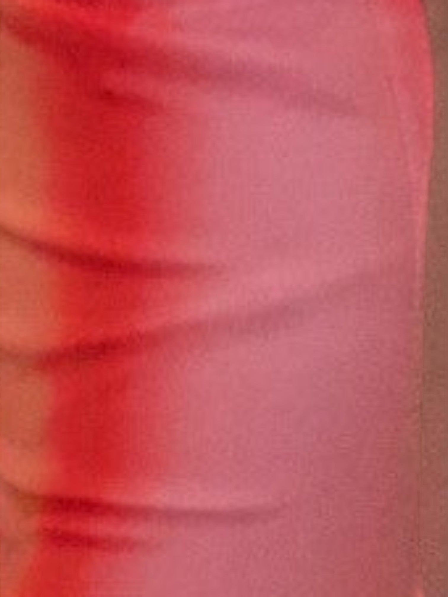 Close-up of the vibrant coral pink fabric of the Mialur Sunset Escape Maxi Dress showing soft texture and folds.