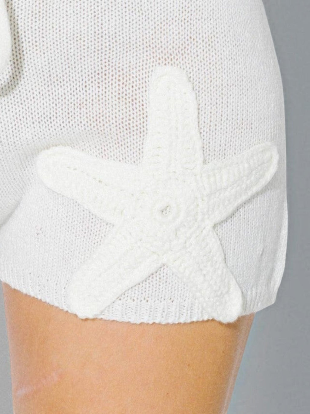 Mialur cream knit drawstring shorts featuring a detailed 3D crochet starfish appliqué on the leg for a coastal look.