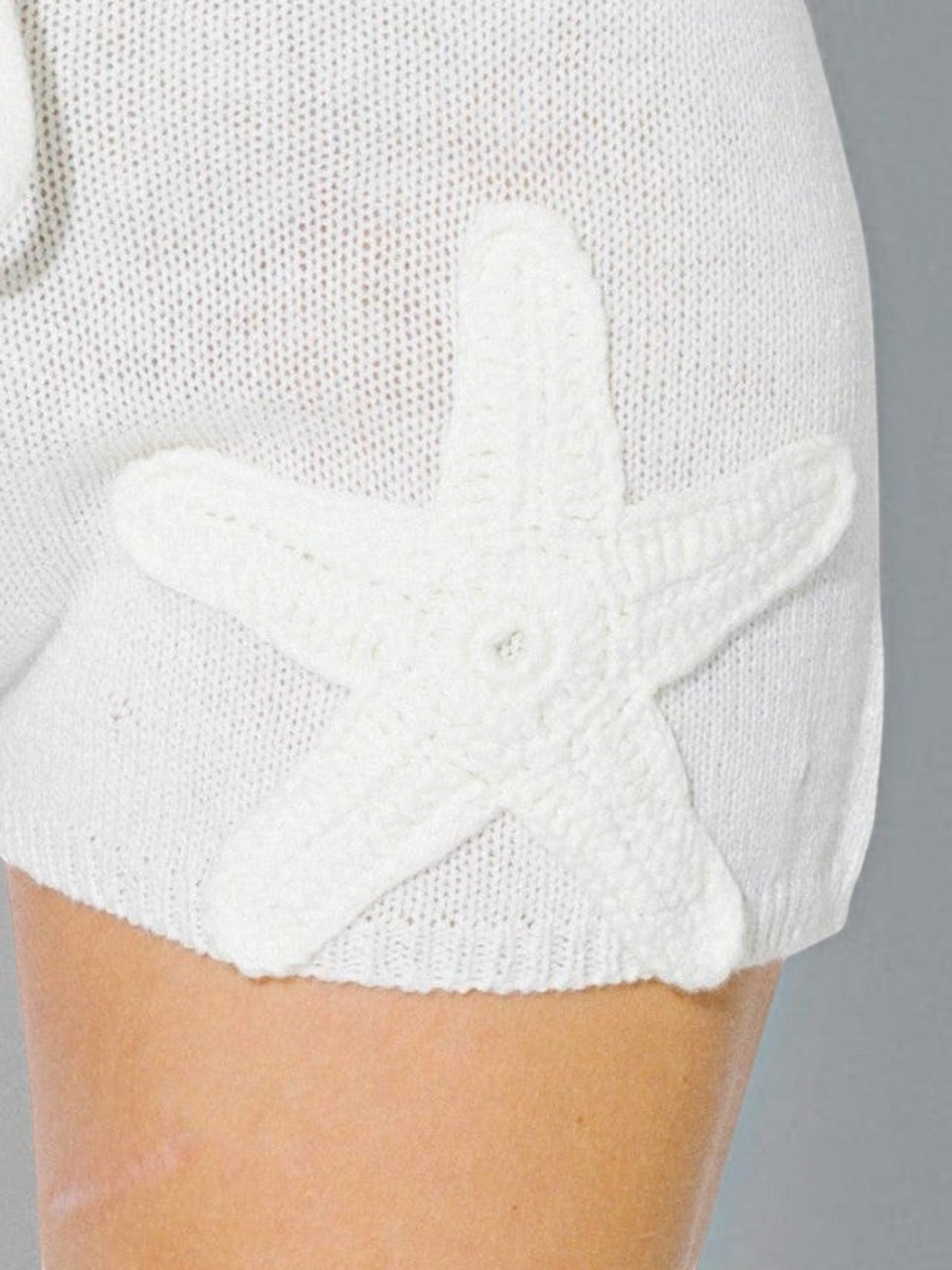 Mialur cream knit drawstring shorts featuring a detailed 3D crochet starfish appliqué on the leg for a coastal look.