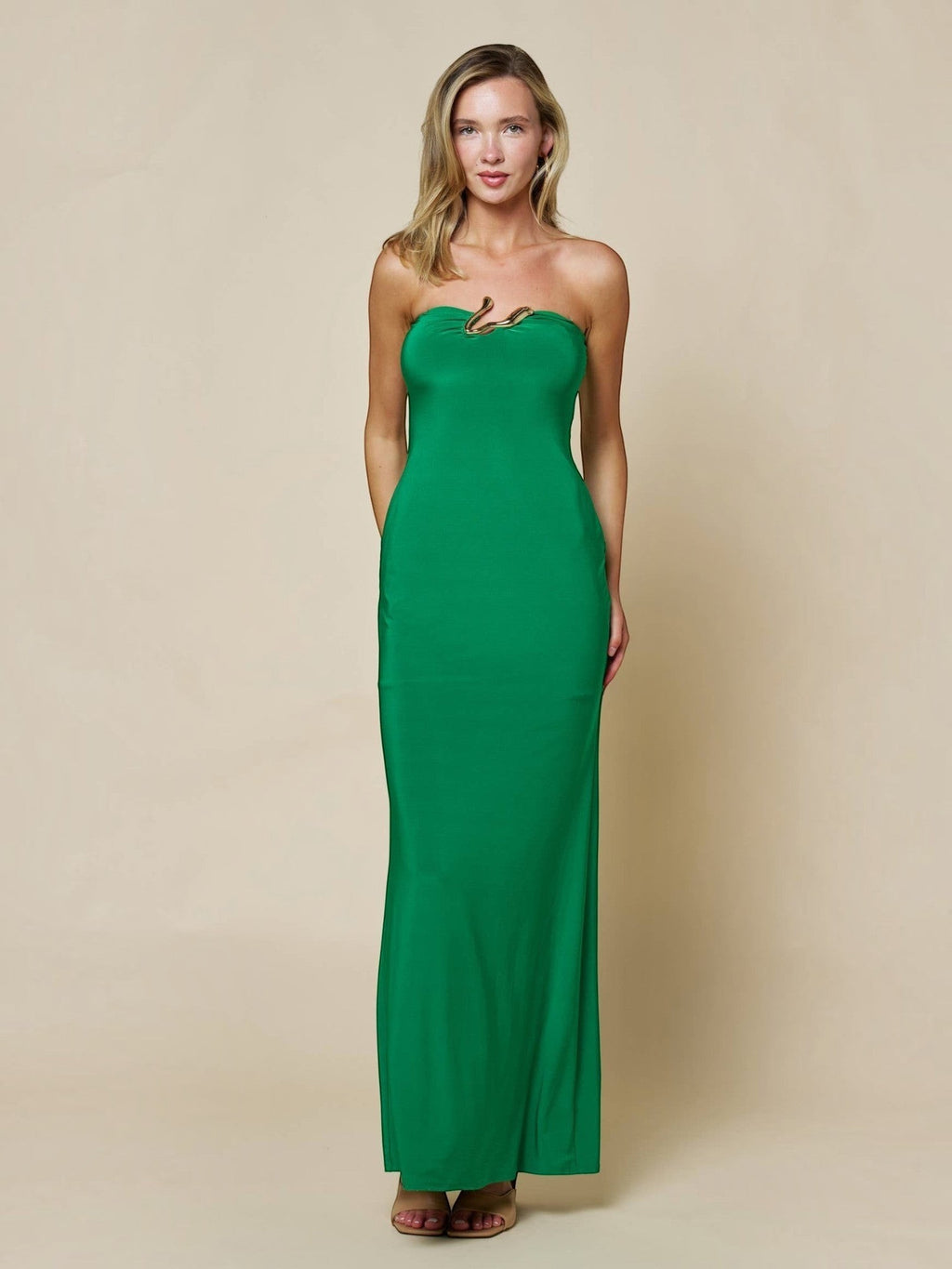 Model wearing Mialur emerald green strapless bodycon maxi dress with gold-tone abstract hardware at the neckline.