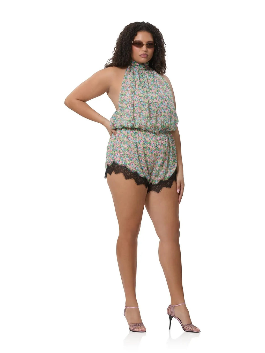 Model wearing Mialur Fleur floral romper with high neckline and black lace trim on a white background