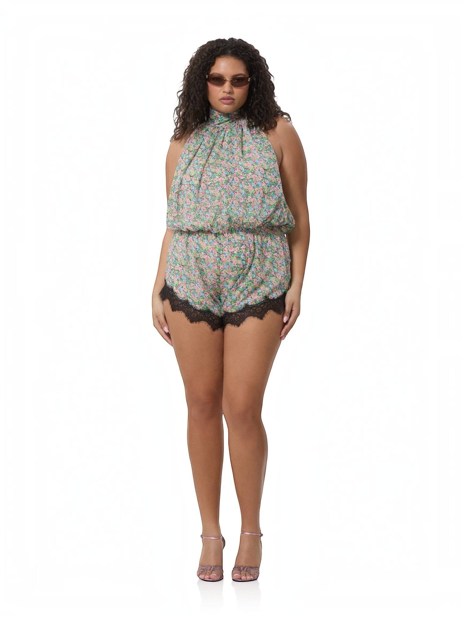 Model wearing Mialur Fleur floral romper with high neckline and black lace trim on a white background