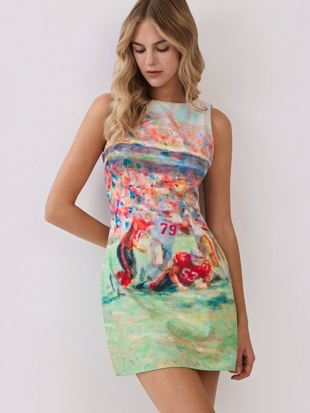 Mialur model wearing a sleeveless mini dress with a colorful abstract football game print and round neckline