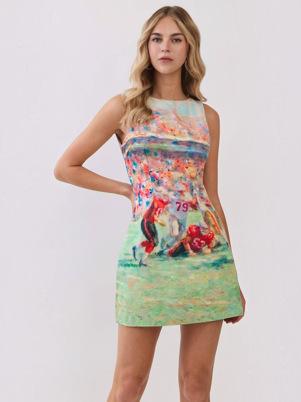 Mialur model wearing a multicolor sleeveless mini dress with an abstract football stadium print and round neckline.