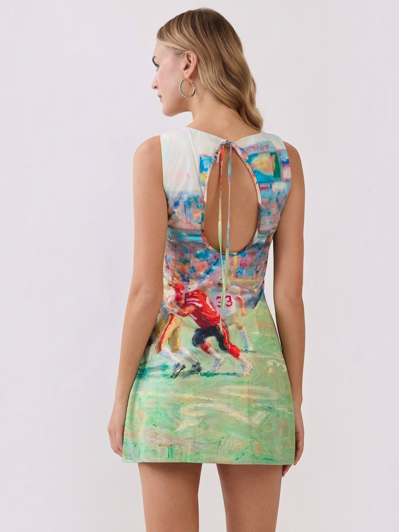 Mialur mini dress with abstract football game print, featuring a round neckline and an open-back keyhole with tie detail.