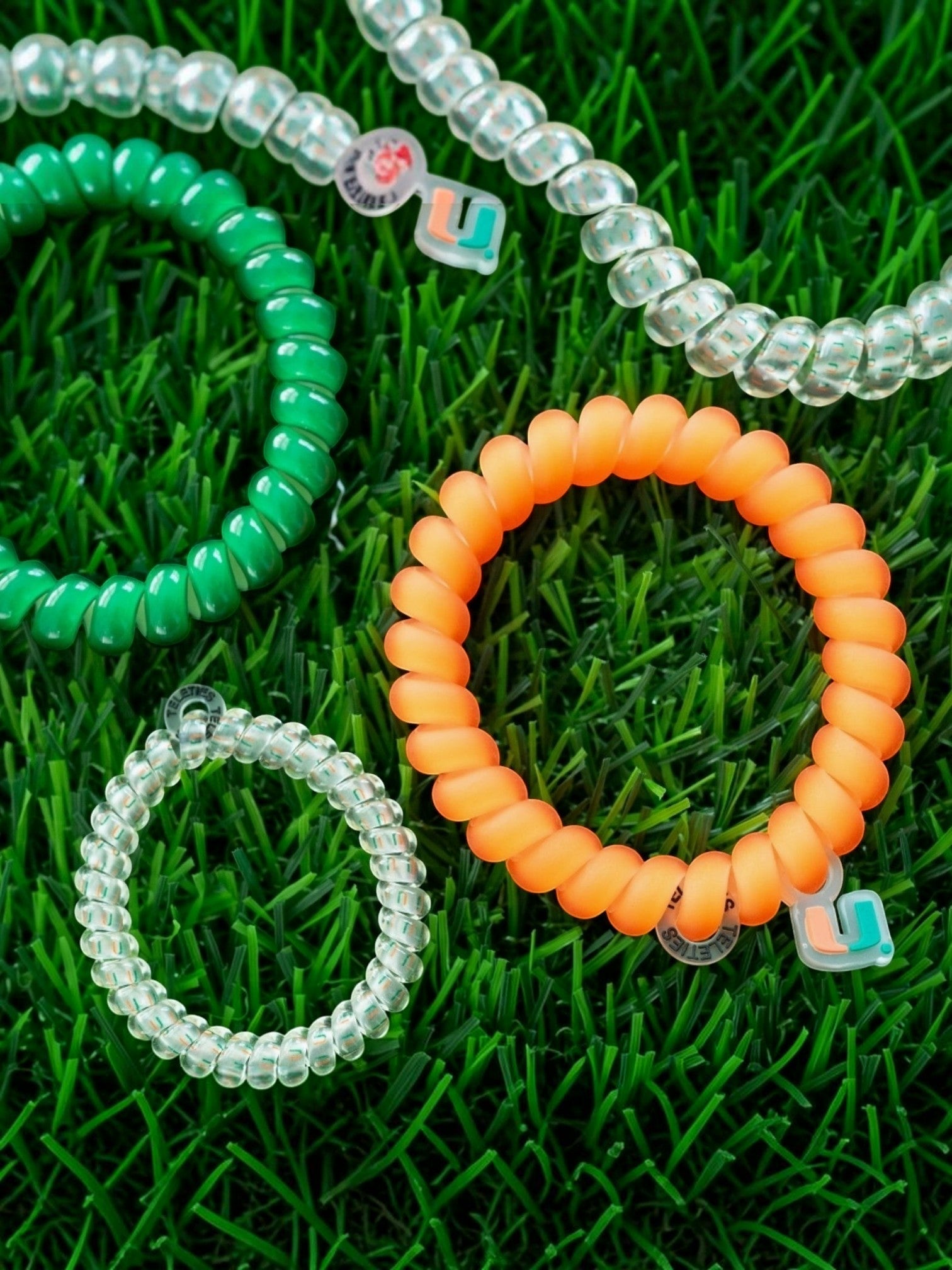 Mialur Go Canes! large spiral hair ties in orange, green, and clear, featuring University of Miami branding.