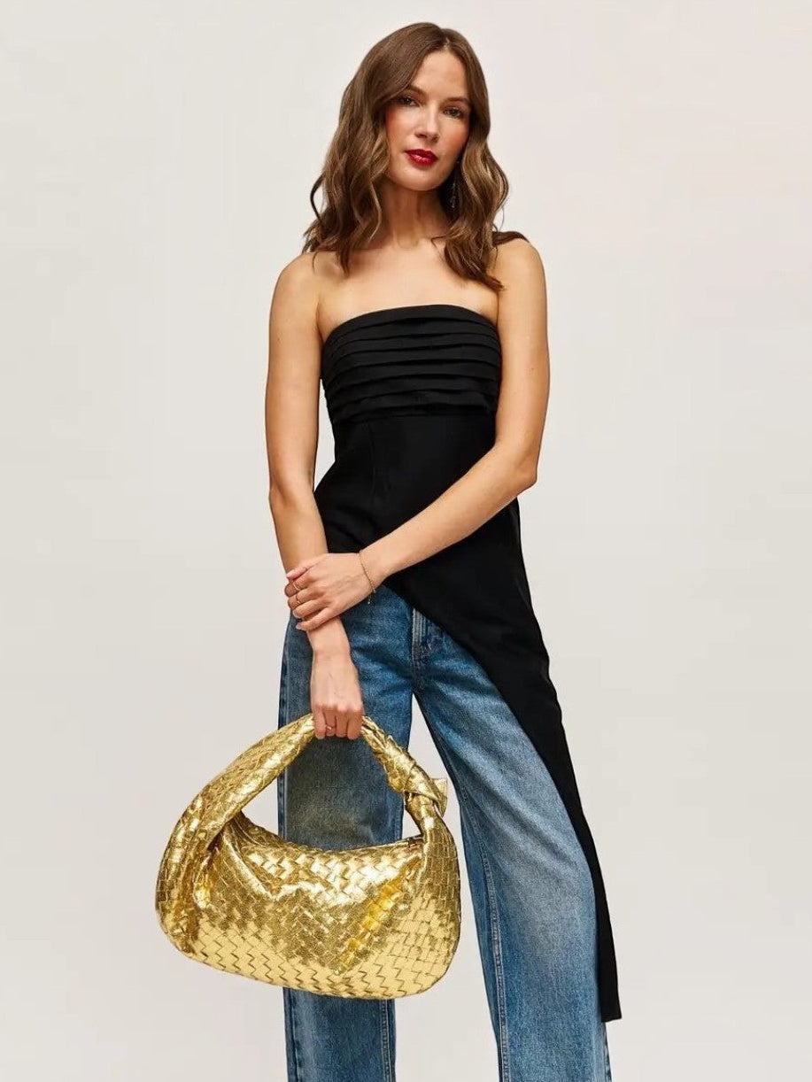 Model wearing a black top and jeans holding a Mialur gold woven hobo bag with a slouchy silhouette.