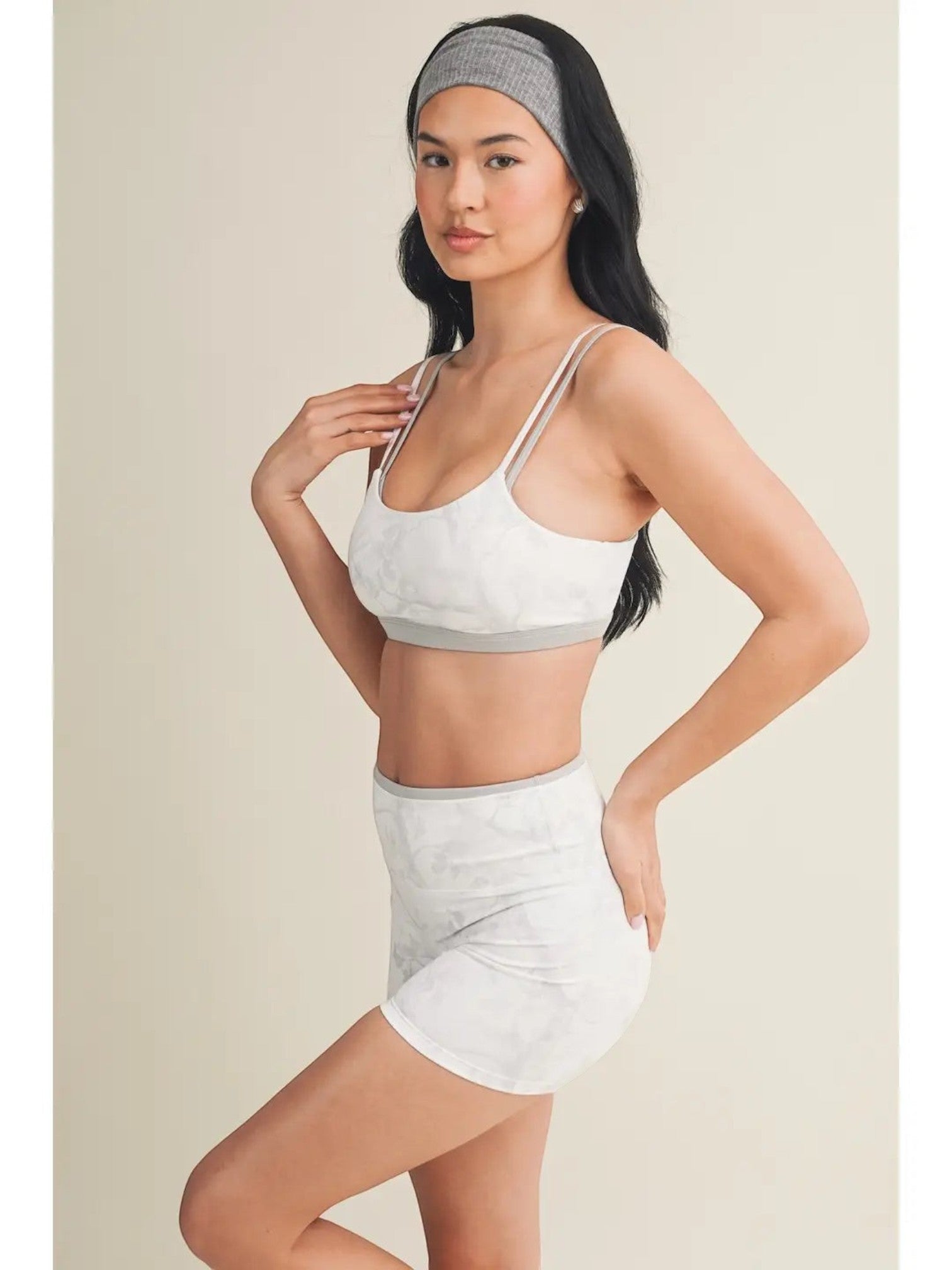 Mialur gray and white camo print double-layered sports bra with thin straps worn by a model with a matching headband.