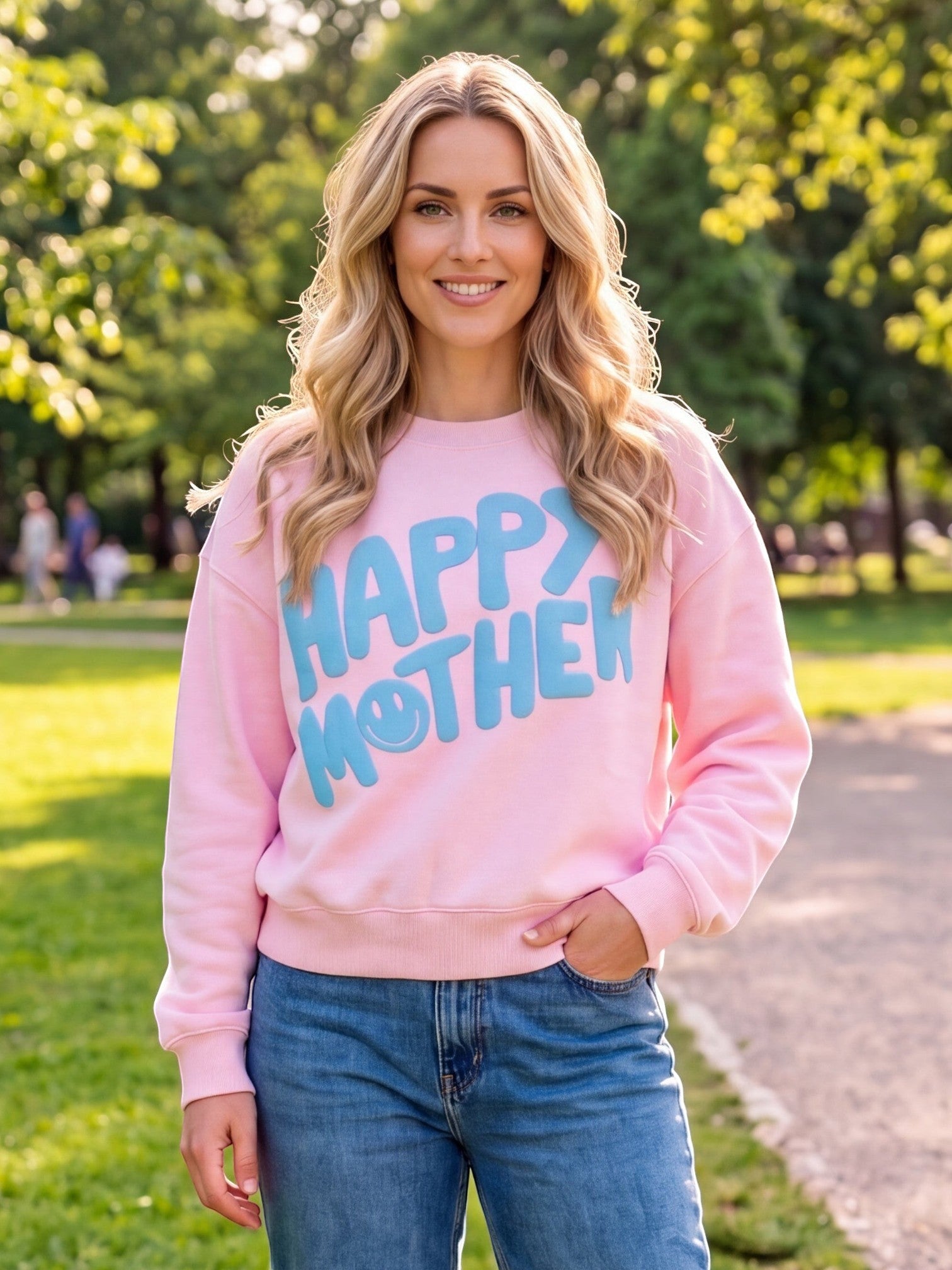 Mialur pink Happy Mom Mock Top sweatshirt with blue HAPPY MOTHER graphic worn by a smiling woman in a park.
