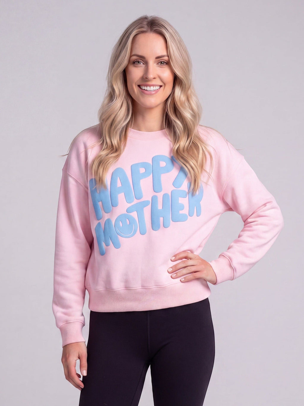 Mialur Happy Mom Mock Top in pink with blue HAPPY MOTHER graphic and smiley face worn by a smiling blonde woman.