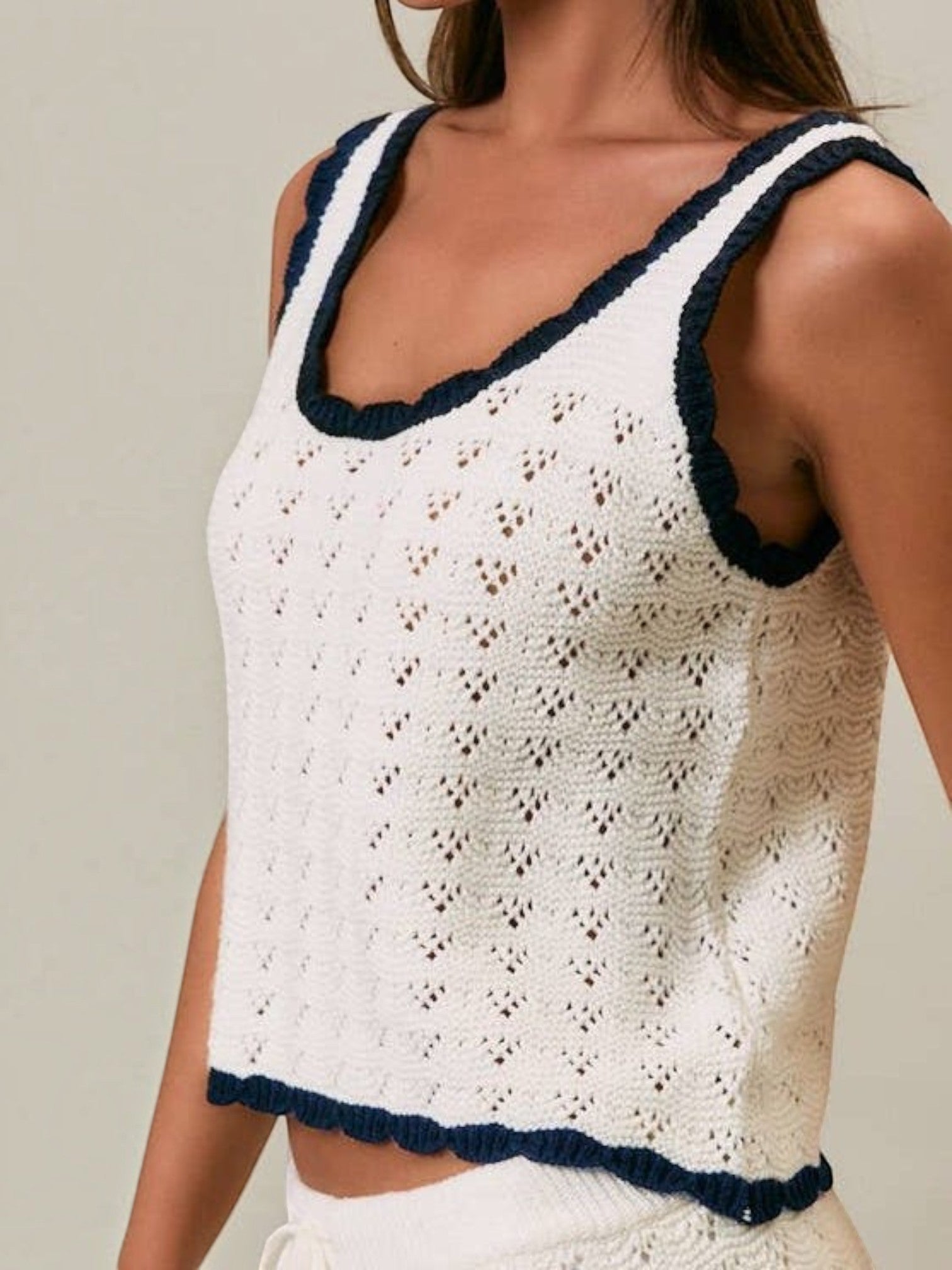 Mialur Harbor Knit Top in white open-knit fabric with navy blue contrast trim on the neckline and hem.