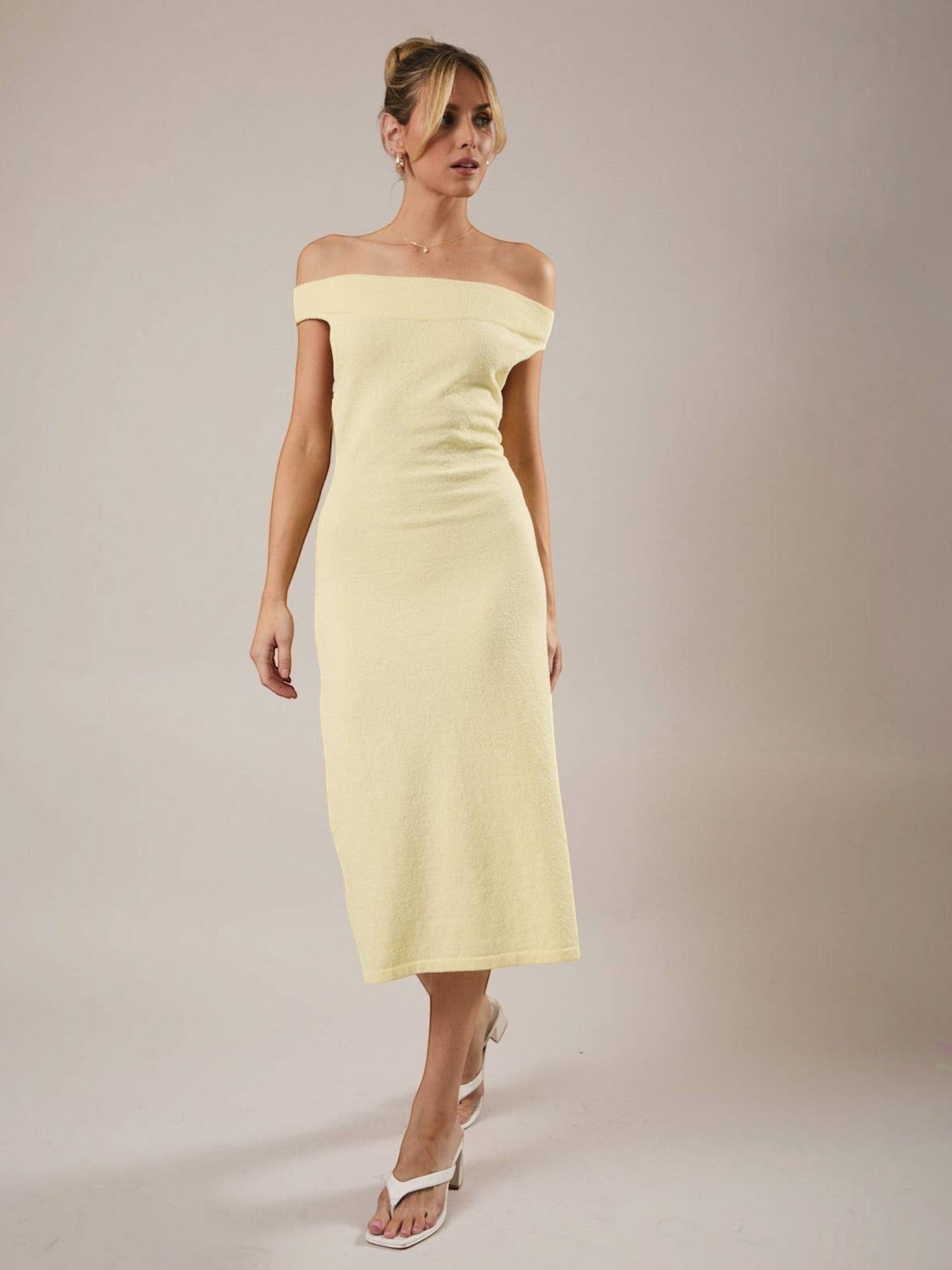 Model wearing a Mialur limoncello yellow off-the-shoulder knit midi dress with a fitted bodice and A-line skirt.