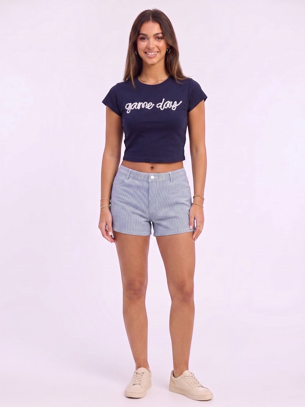 Mialur navy fitted baby tee with white game day script worn by a model with striped shorts and sneakers