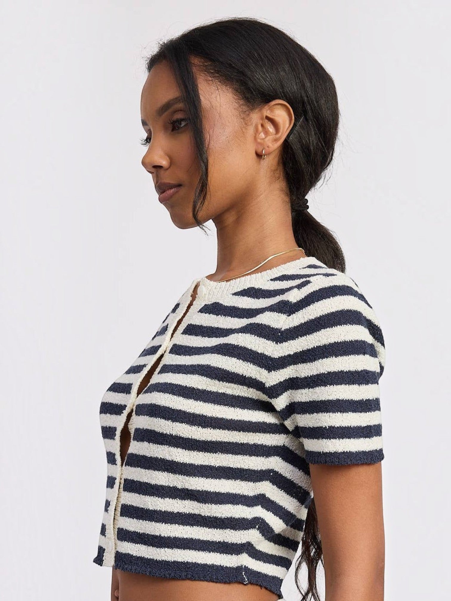 Model wearing a Mialur navy and white horizontal striped short-sleeve knit top with a button-front placket.