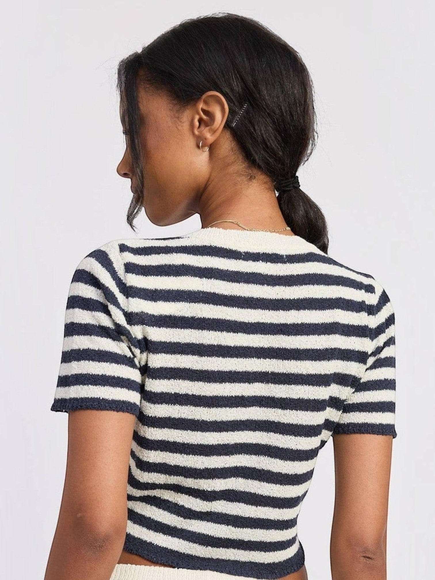 Back view of a woman wearing a Mialur navy and white horizontal striped short-sleeve textured knit top.