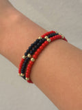 Mialur Newport triple-strand beaded bracelet featuring red, navy, and gold-tone beads on a wrist.