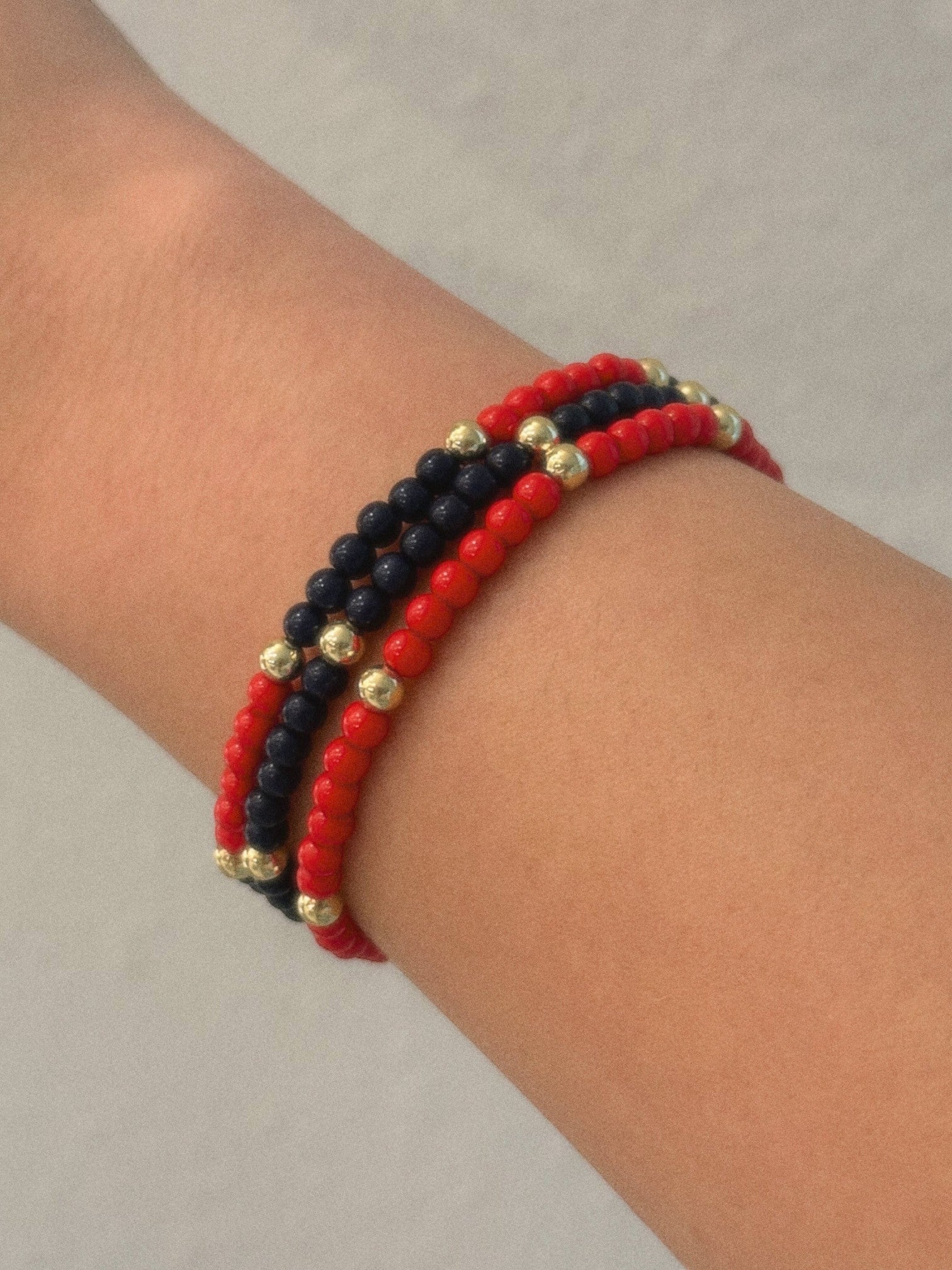 Mialur Newport triple-strand beaded bracelet featuring red, navy, and gold-tone beads on a wrist.